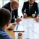 Image representing the initial consultation and planning phase with clients and the Maxbanka Construction Group team reviewing documents and plans.
